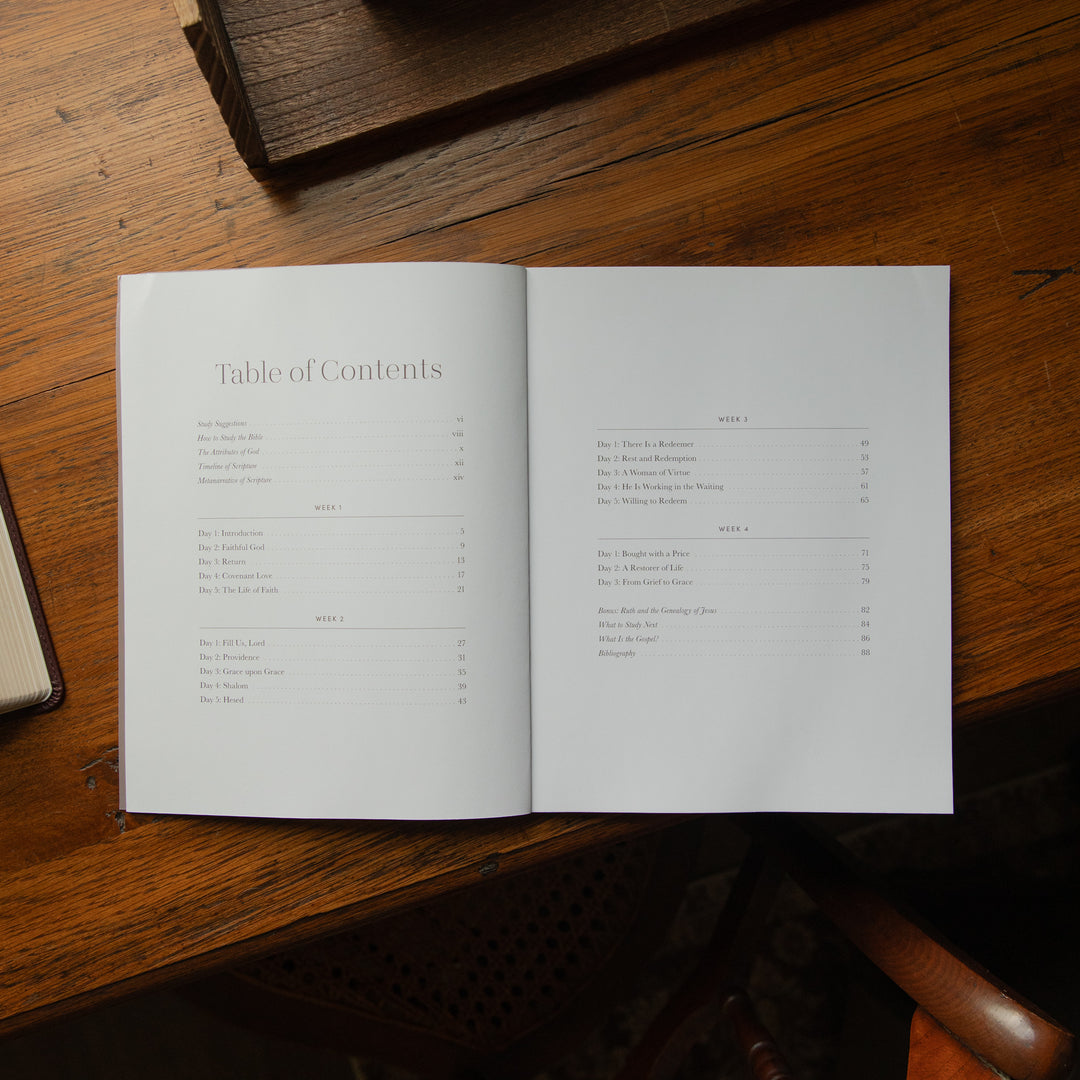 An open book showing the Table of Contents spread on a warm wooden table.