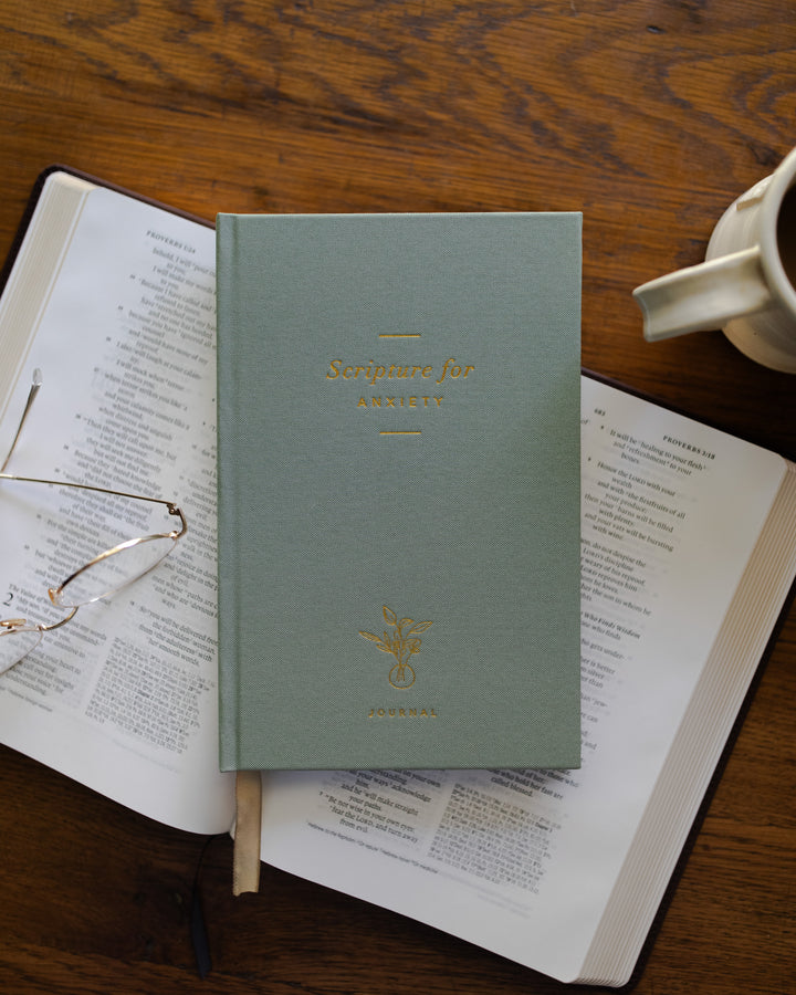 A Green journal laying on top of a BIble. 