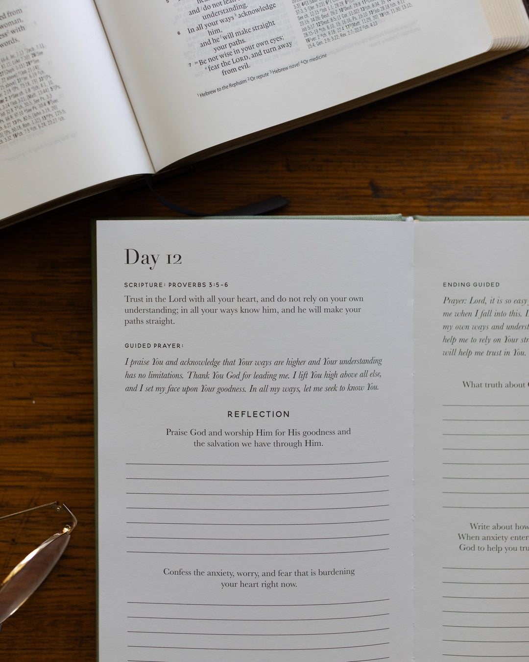 Open book with a prayer journal on a wooden surface