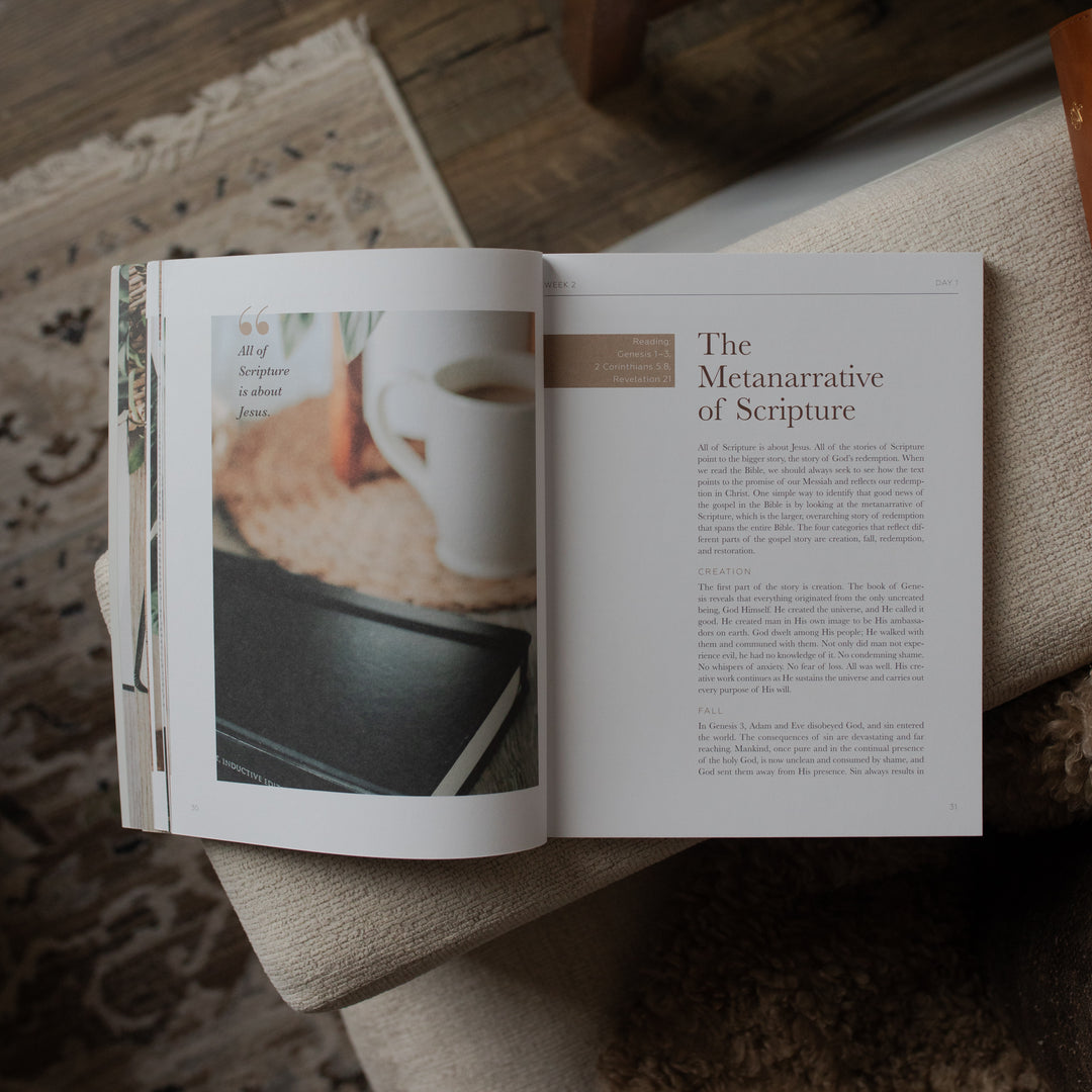Open book on a textured surface with a cup of coffee and bread in the background