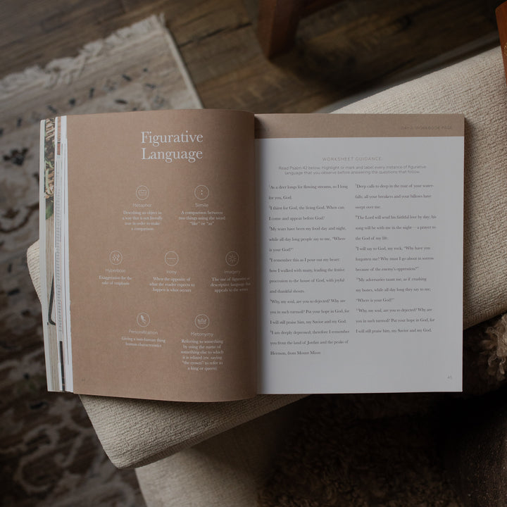 Open book on a wooden surface with text and illustrations.