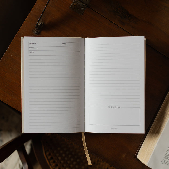 Open notebook with lined pages on a wooden surface