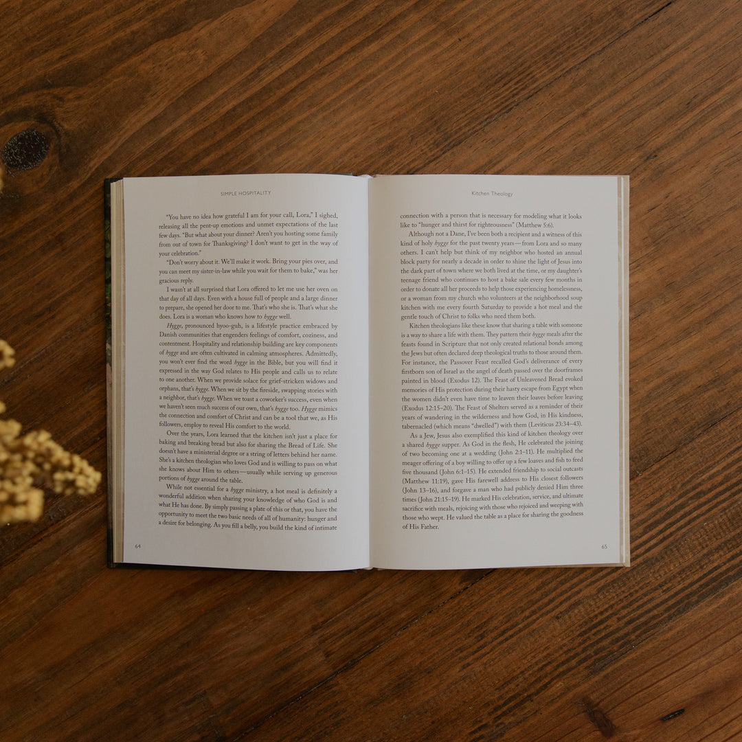 An open book displaying two pages of printed text, placed flat on a dark brown wooden surface.