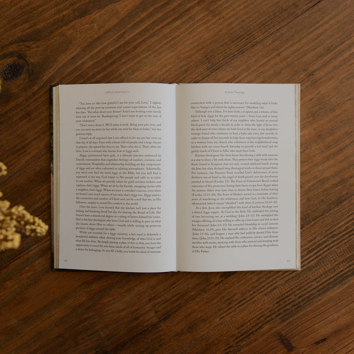 An open book displaying two pages of printed text, placed flat on a dark brown wooden surface.