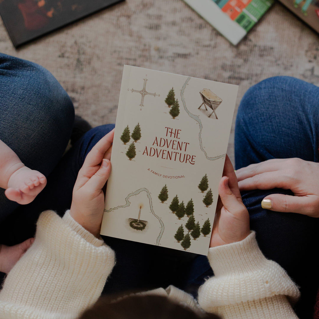 A child holding the Advent Adventure Devotional cover