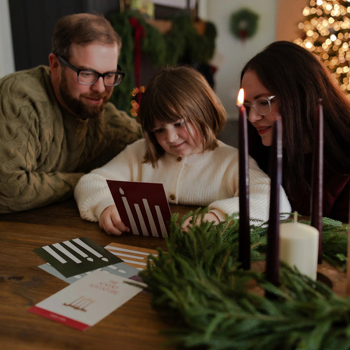 A family reading the Advent Adventure Cards while sitting at a wooden table