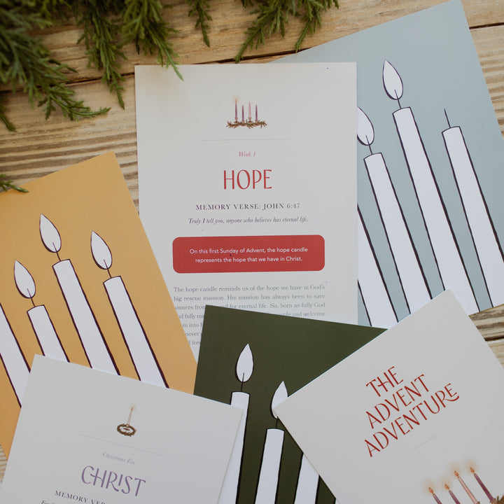 Multiple Advent Adventure Cards scattered on a light colored wooden table