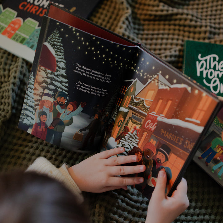 A child reading The Advent Gift book over a textured blanket