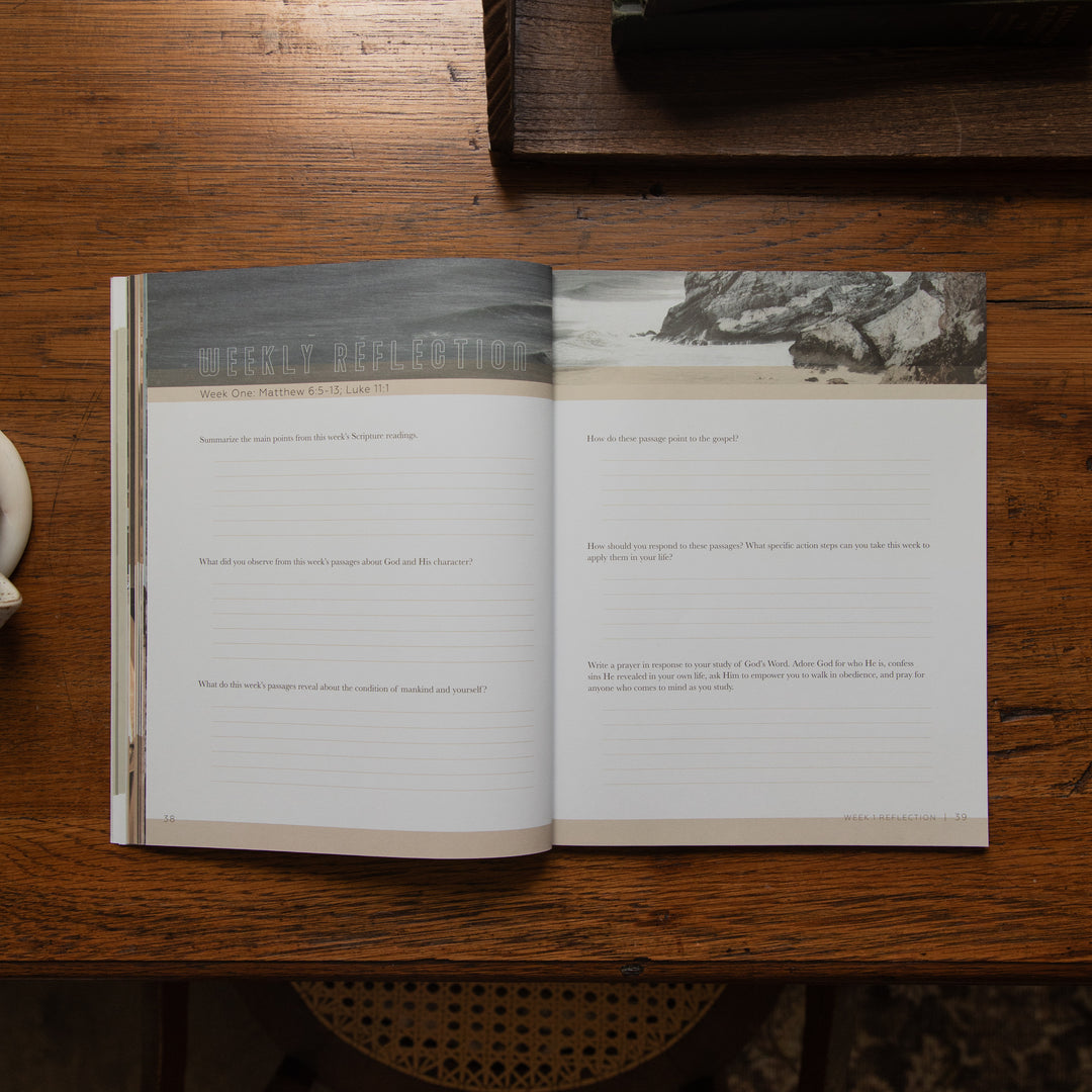 An open Bible study book titled 'The Great Escape' laid flat on a dark wooden table, showing two pages with printed scripture and landscape photographs at the top.