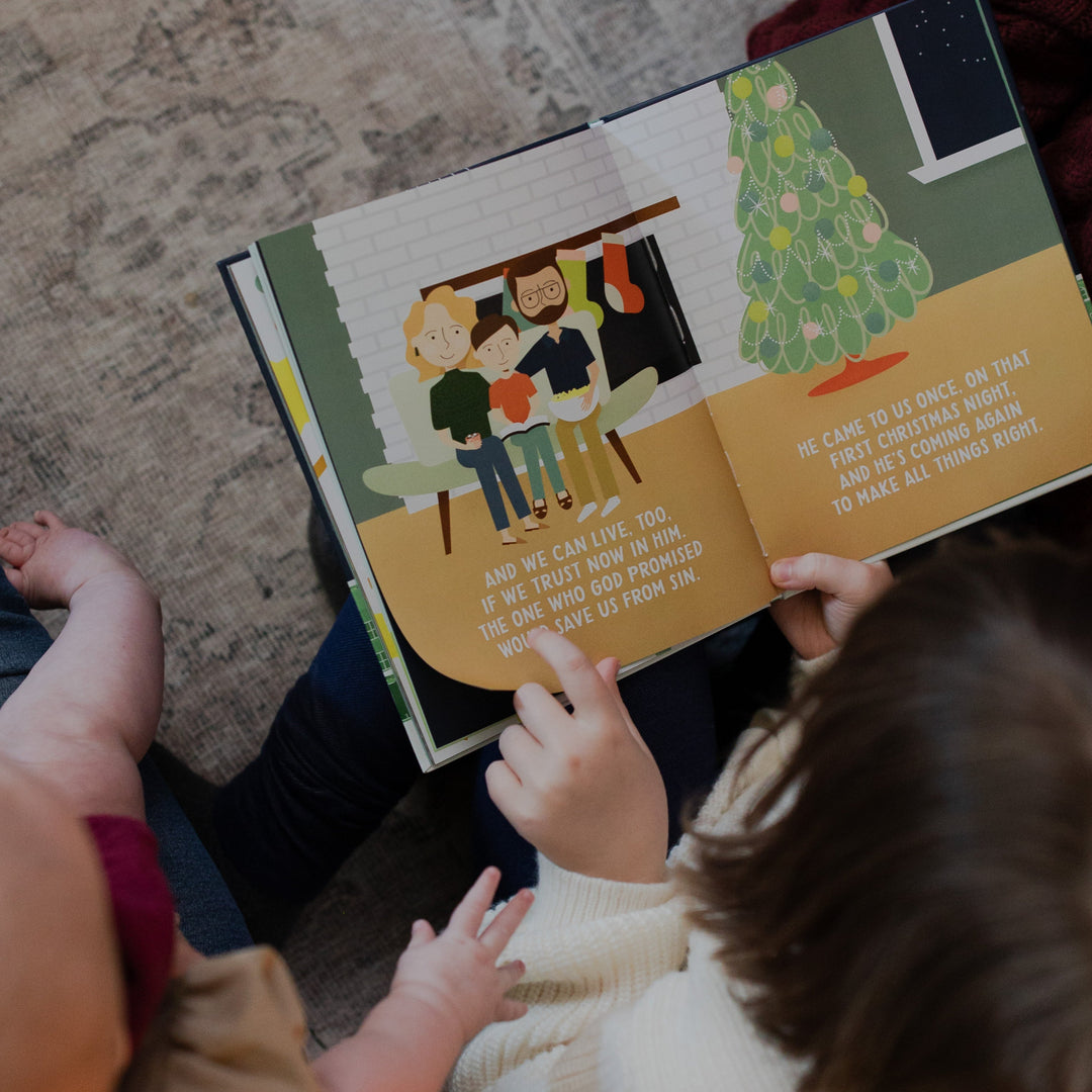 A child pointing to a page in the Promise of Christmas board book