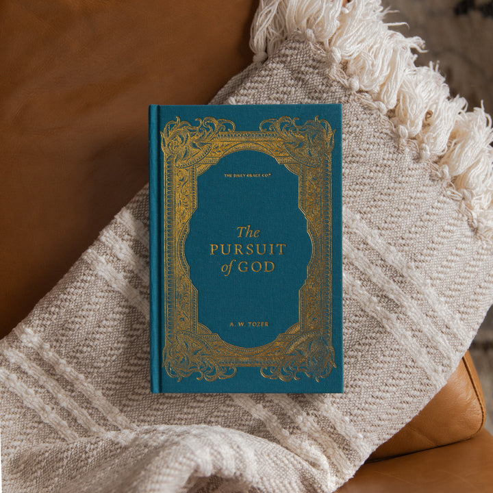 The Pursuit of God cover on a cream blanket and leather couch