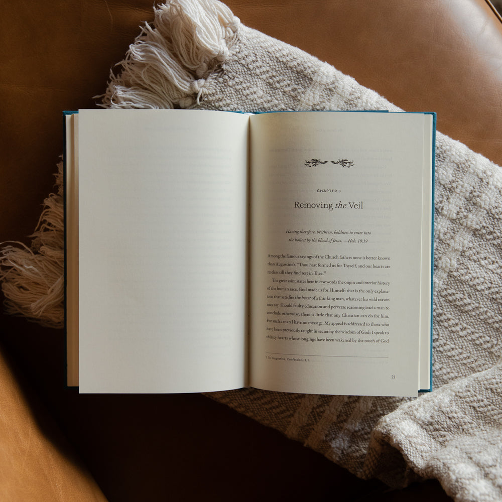 The Pursuit of God opened to Chapter 3 on a cream blanket and leather couch