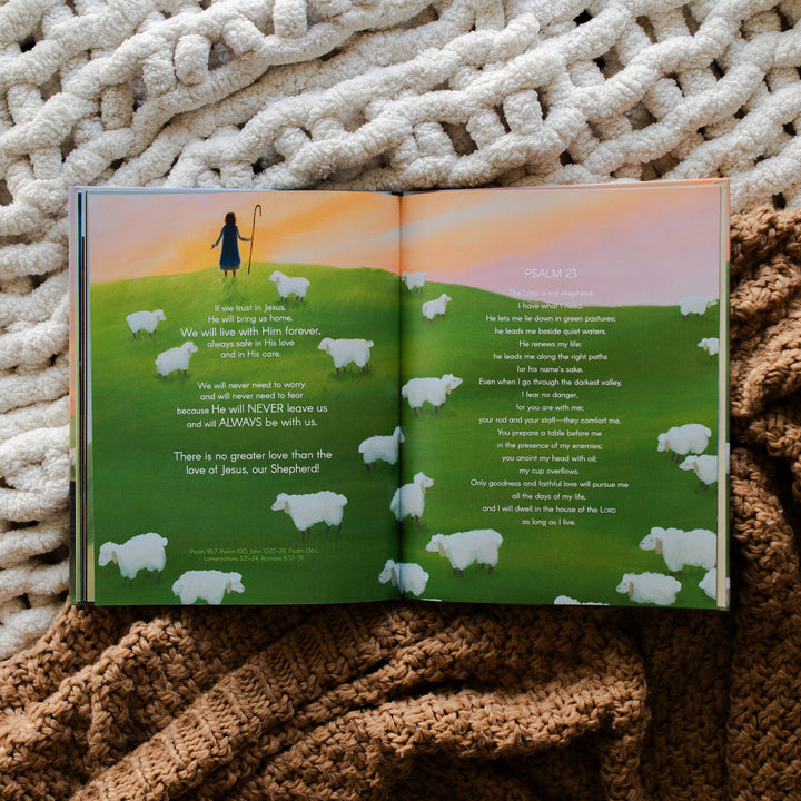 The Story of the Lost Sheep Book ending page of the book with a man overlooking a sunset with multiple sheep around him; the book is laying on two blankets, one brown and one cream colored