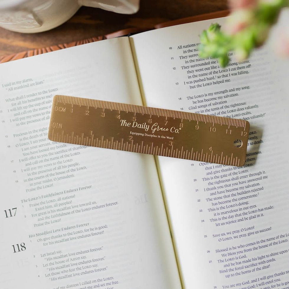 brass ruler on back of bookmark on top of book