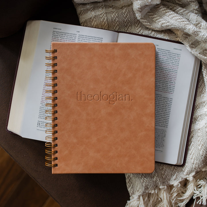 Theologian journal on an open bible and a leather couch