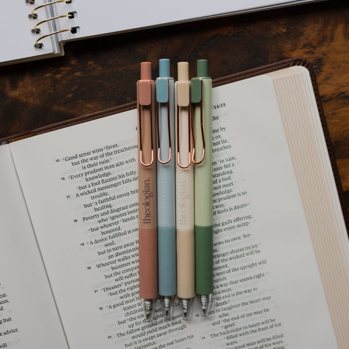 4 Theologian Pens laying on an open bible