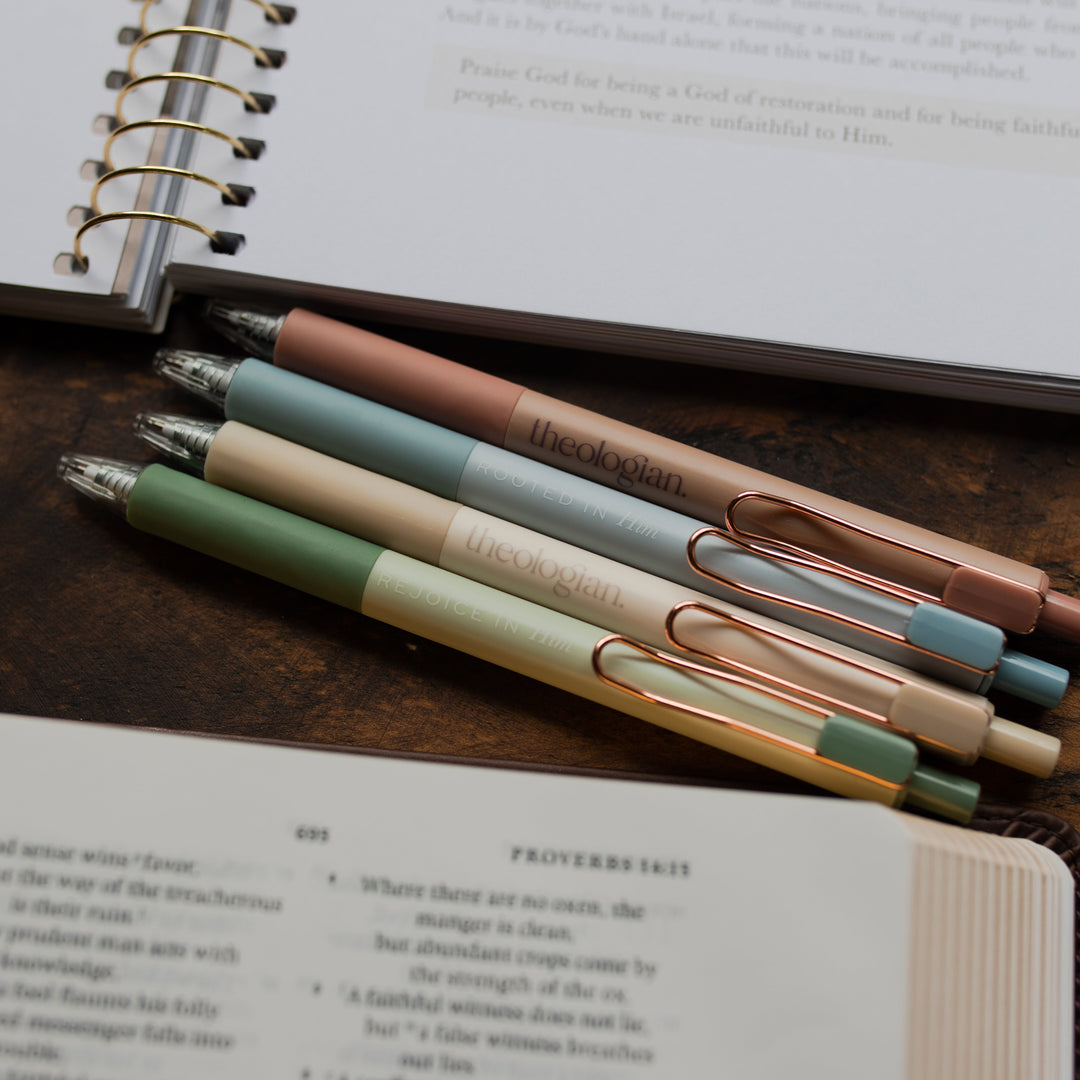 4 Theologian Pens laying above an open bible and an open journal