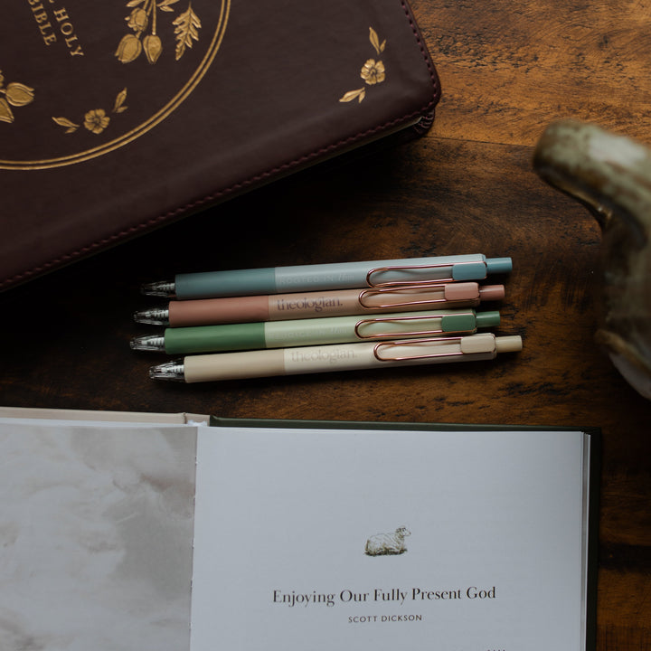4 Theologian Pens laying above an open book and near a closed bible