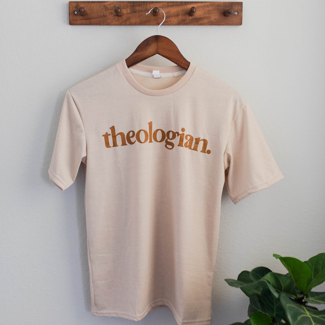 theologian tee shirt hanging on a hanger