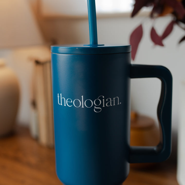 Up close of A blue tumbler with the words theologian on it