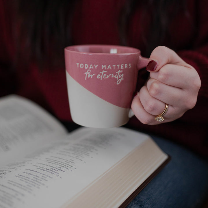 Woman holding Today Matters for Eternity ceramic mug while reading the Bible