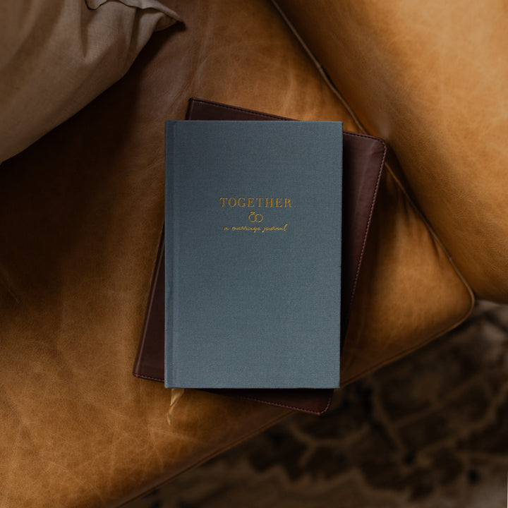 Blue book titled 'Together' on a brown leather surface