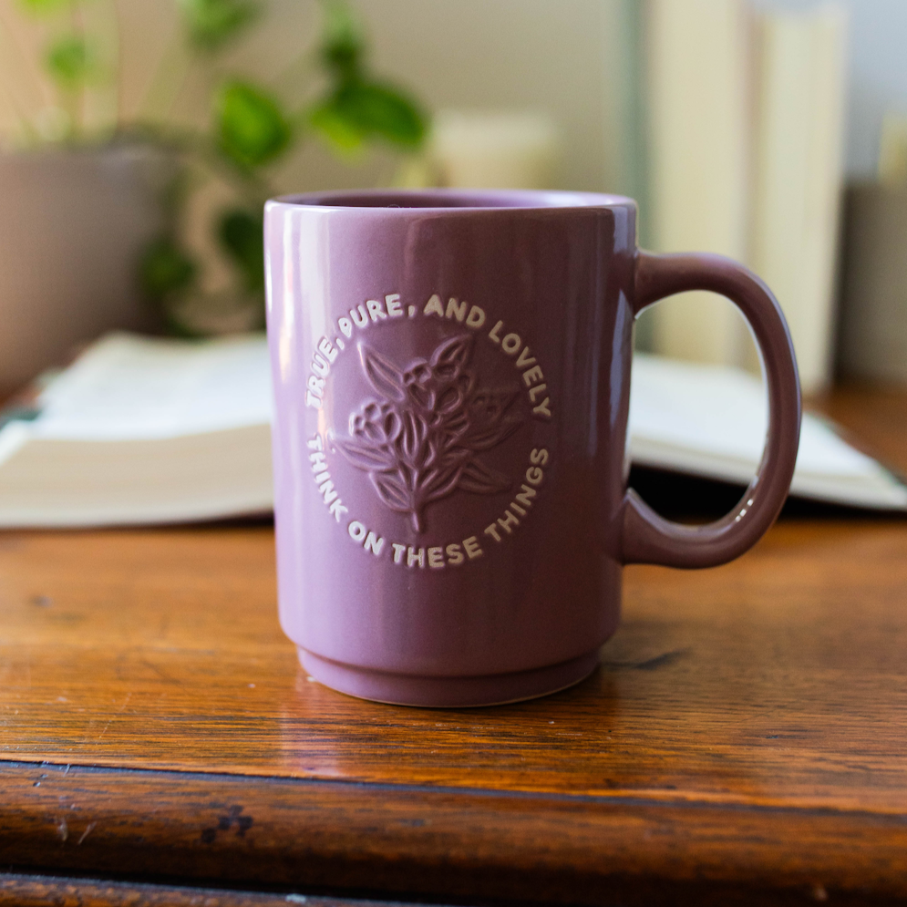 coffee mug with text and embossed graphic on table