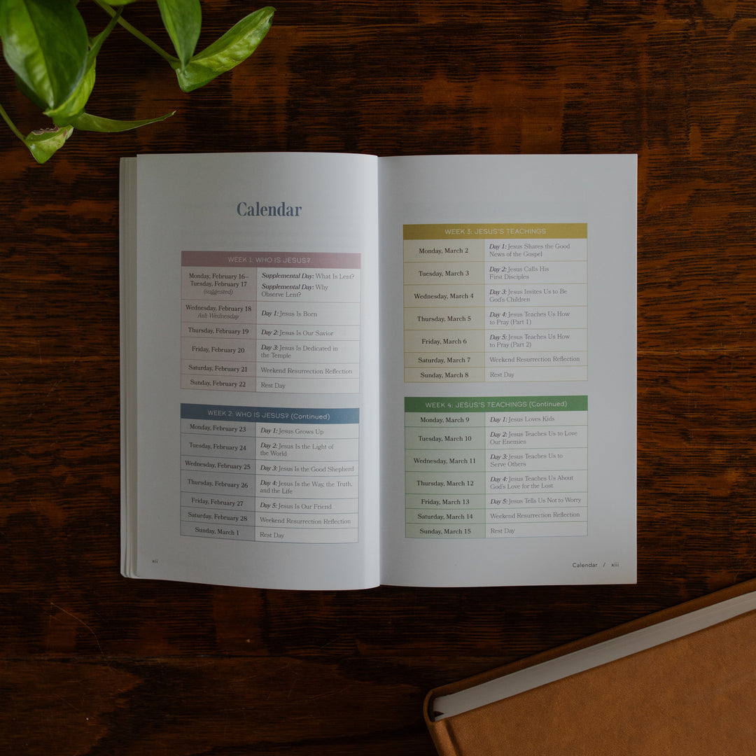 Walking with Jesus Study opened to the calendar page on a wooden table near some greenery and a closed journal