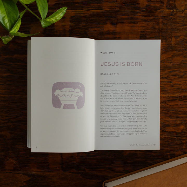 Walking with Jesus Study opened to the Jesus is Born page on a wooden table near some greenery and a closed journal