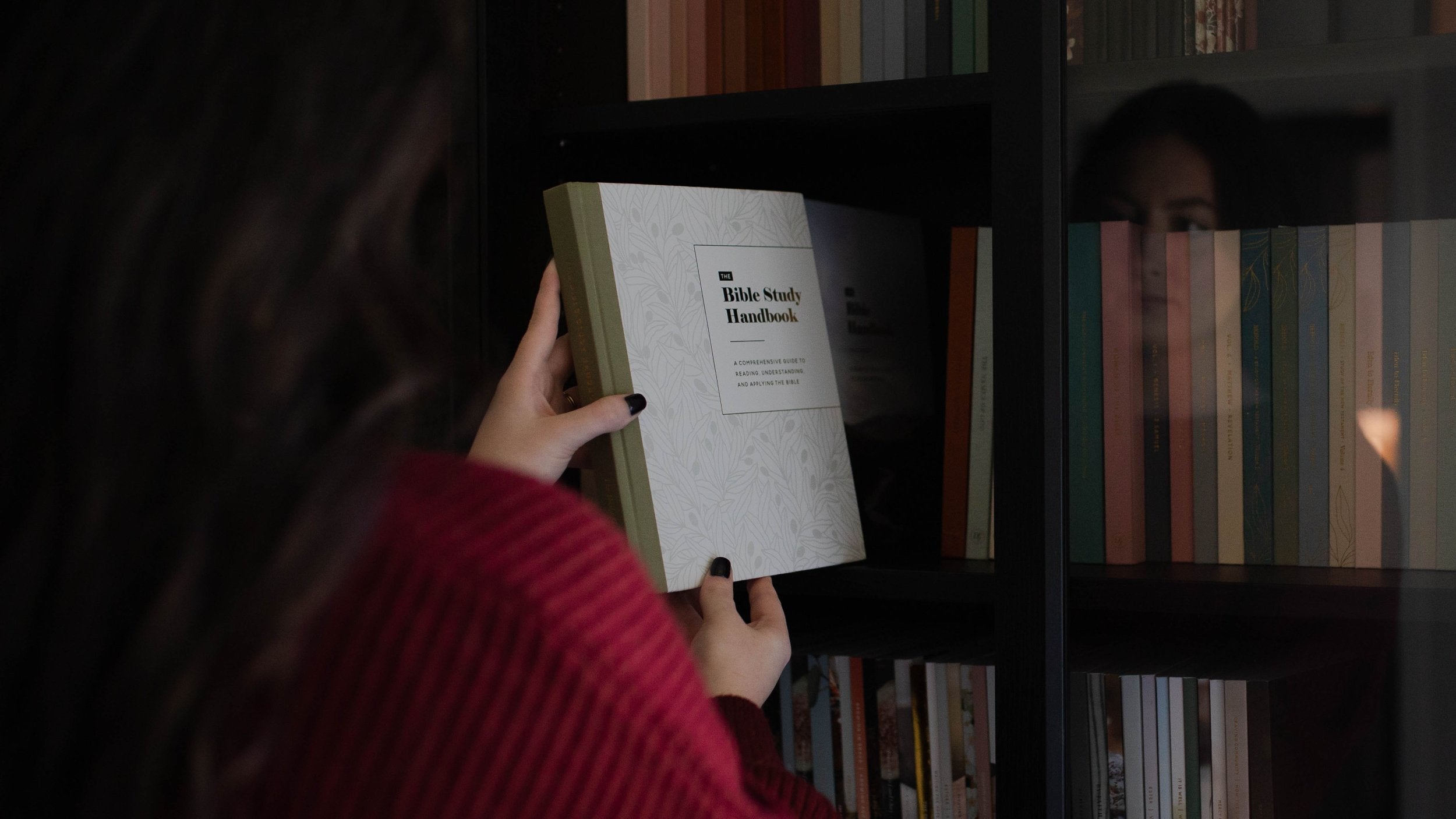 Woman placing the Bible Study Handbook onto a shelf