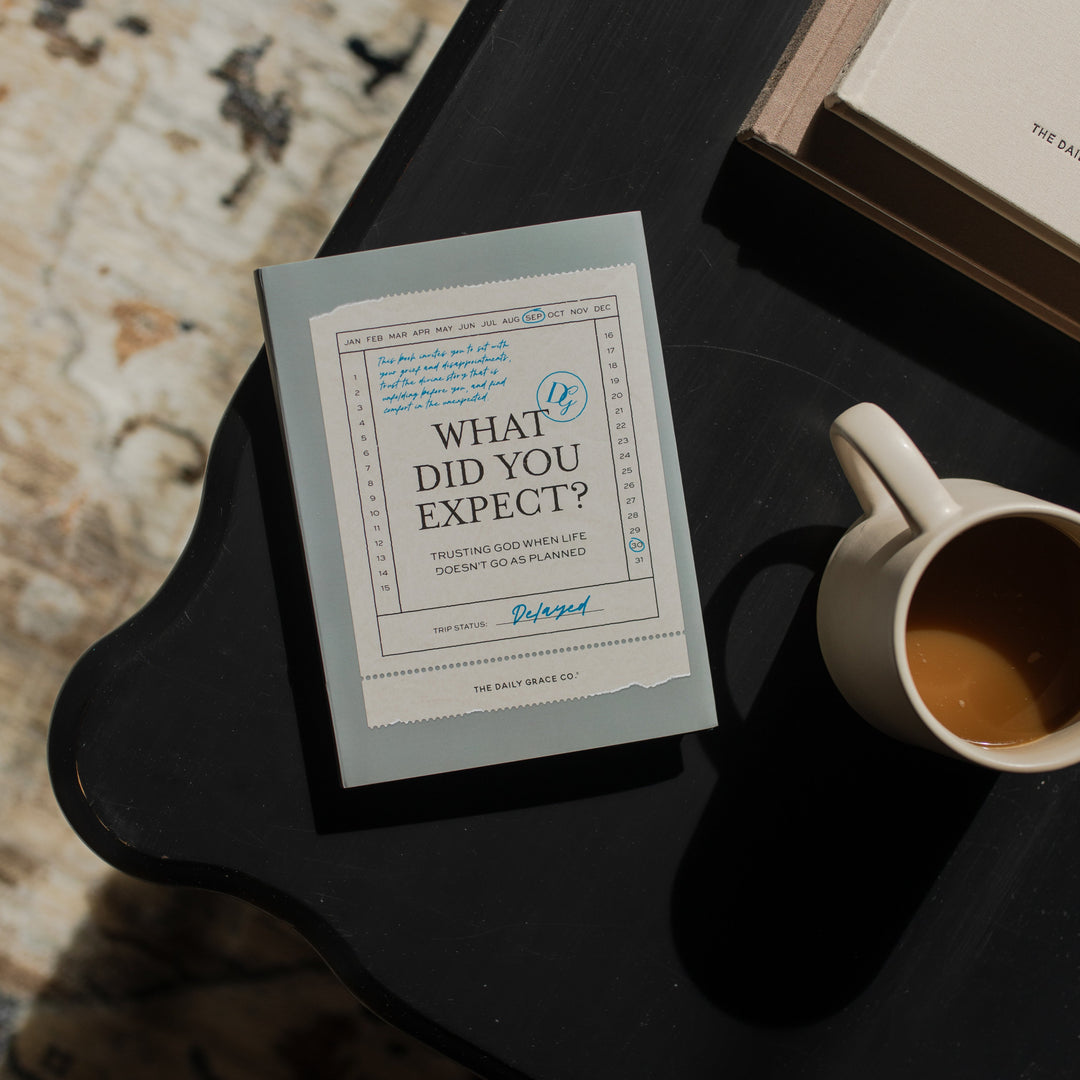 What did you expect book cover on a black wooden table near a coffee cup
