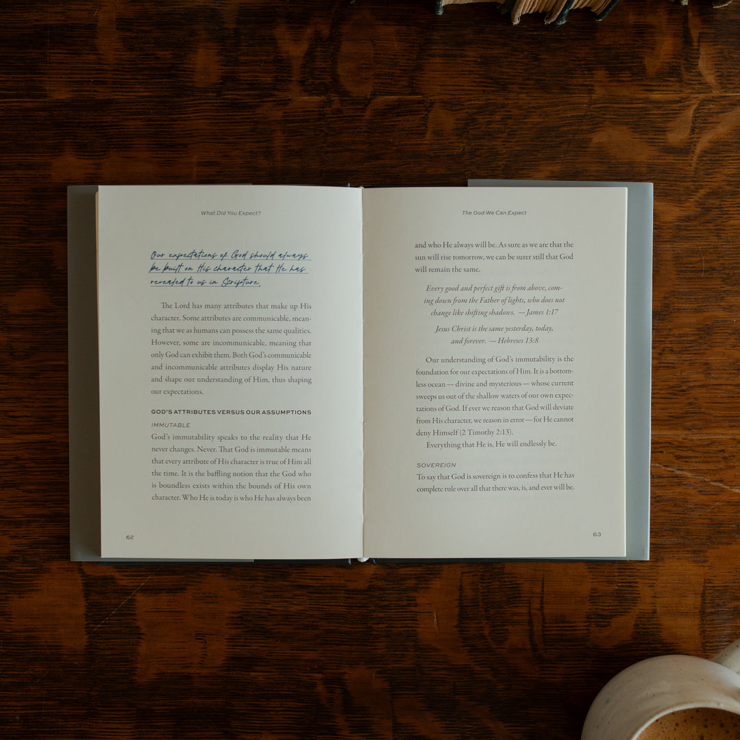 What did you expect book opened to page 62 on a wooden table near a coffee cup