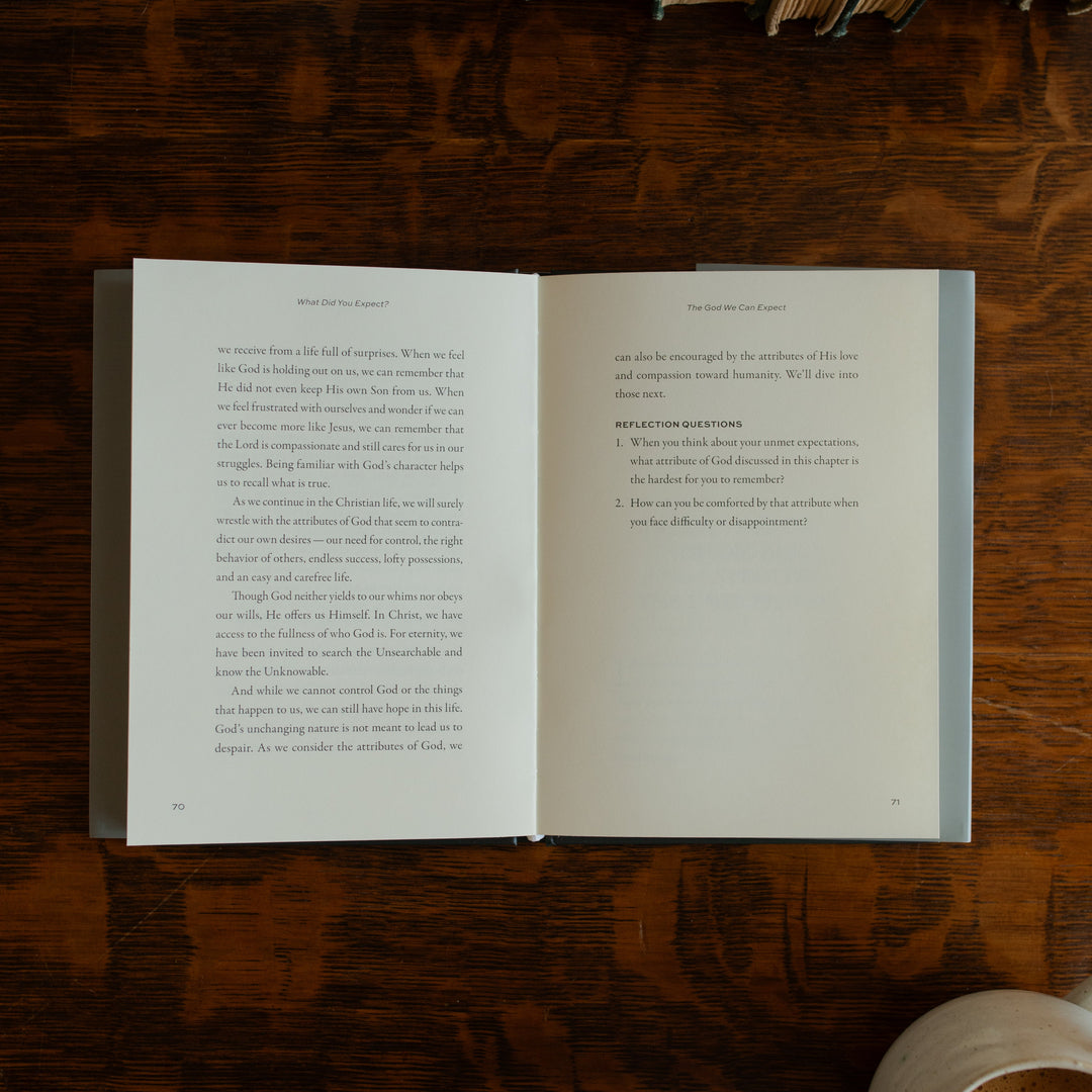 What did you expect book opened to page 70 on a wooden table near a coffee cup