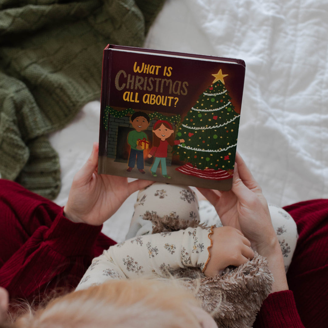 Mom and daughter holding What Is Christmas All About? board book