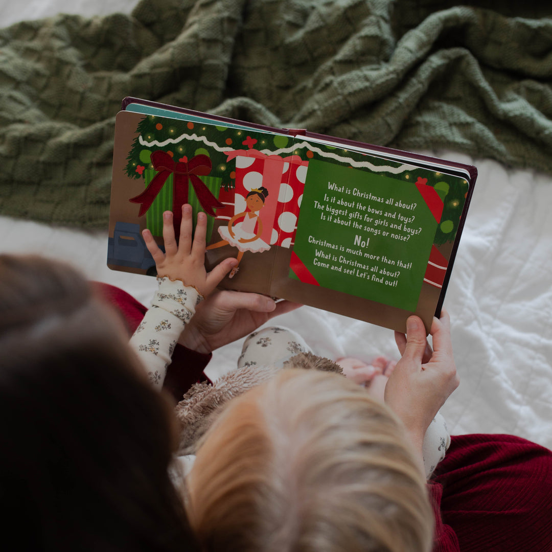 Family reading What is Christmas All About? Children's Christmas board book