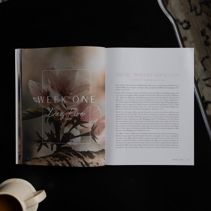 Open book with floral design and text on a dark surface