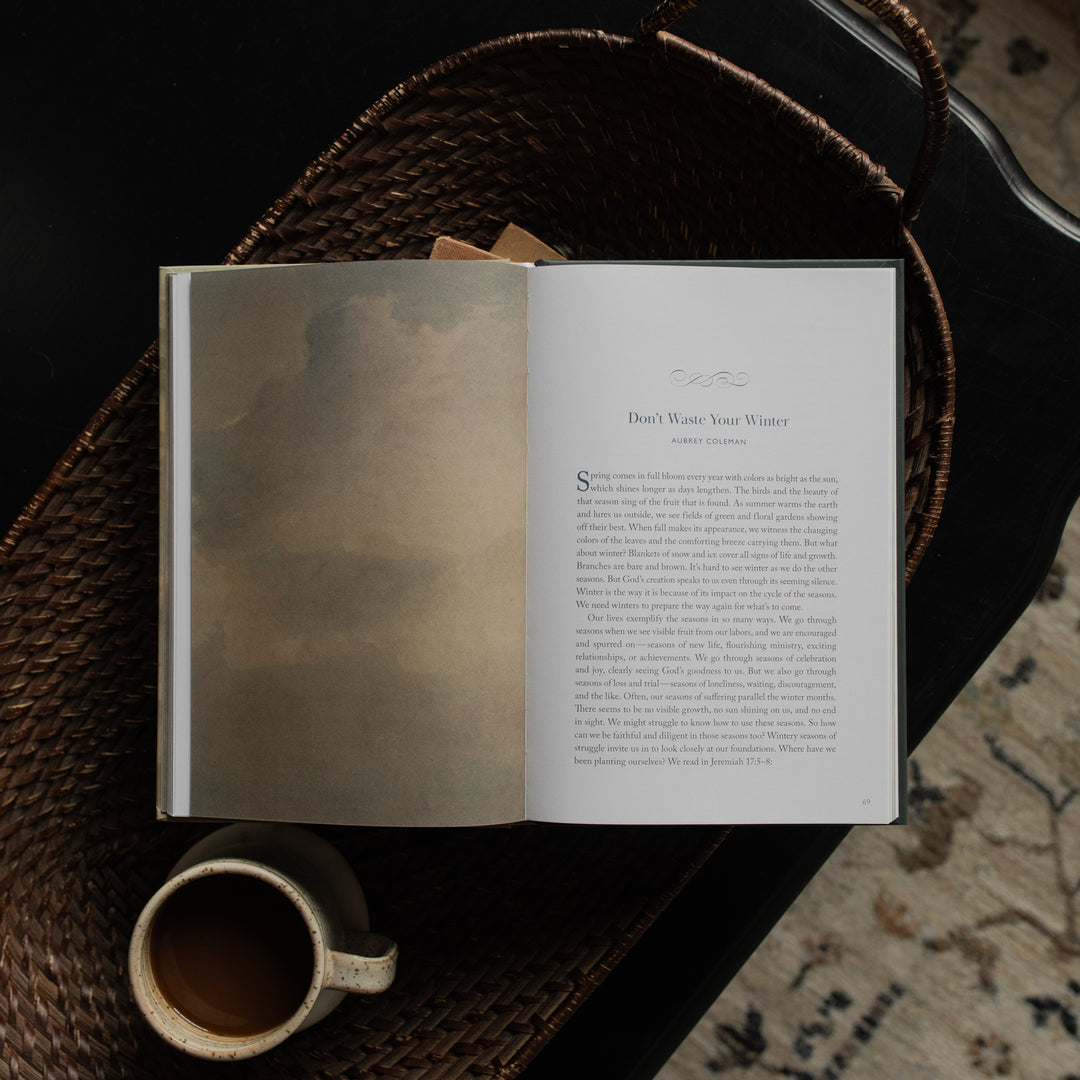 When Storms Rage opened to the Don't Waste Your Winter Page on other books near a coffee cup in a woven basket