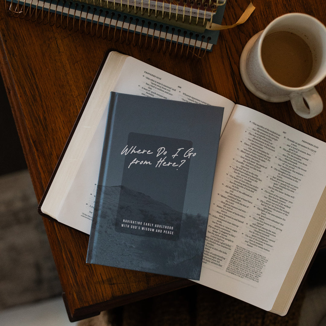 Where Do I Go From Here Study cover resting on an open bible on a brown wooden table next to a coffee cup and a stack of spiral journals