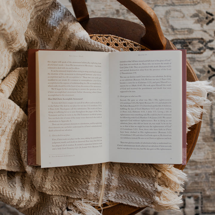 Why Did Jesus Have To Die opened to the questions 10 page on a blanket and a woven chair