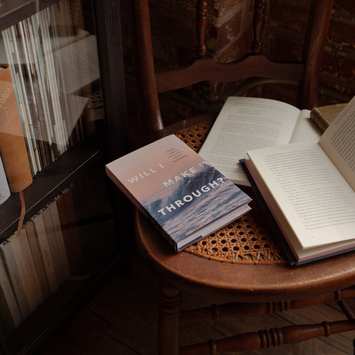 Will I Make It Through hardcover cover on a wooden and woven chair near an open book