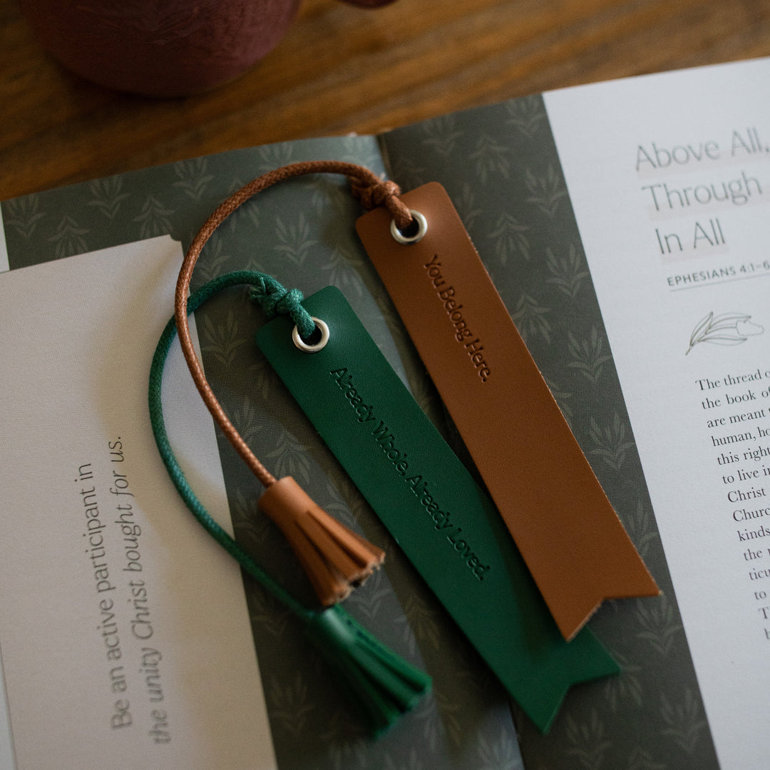 You Belong Here Leatherette Bookmarks laying on an open bible study on a wooden table next to a coffee mug