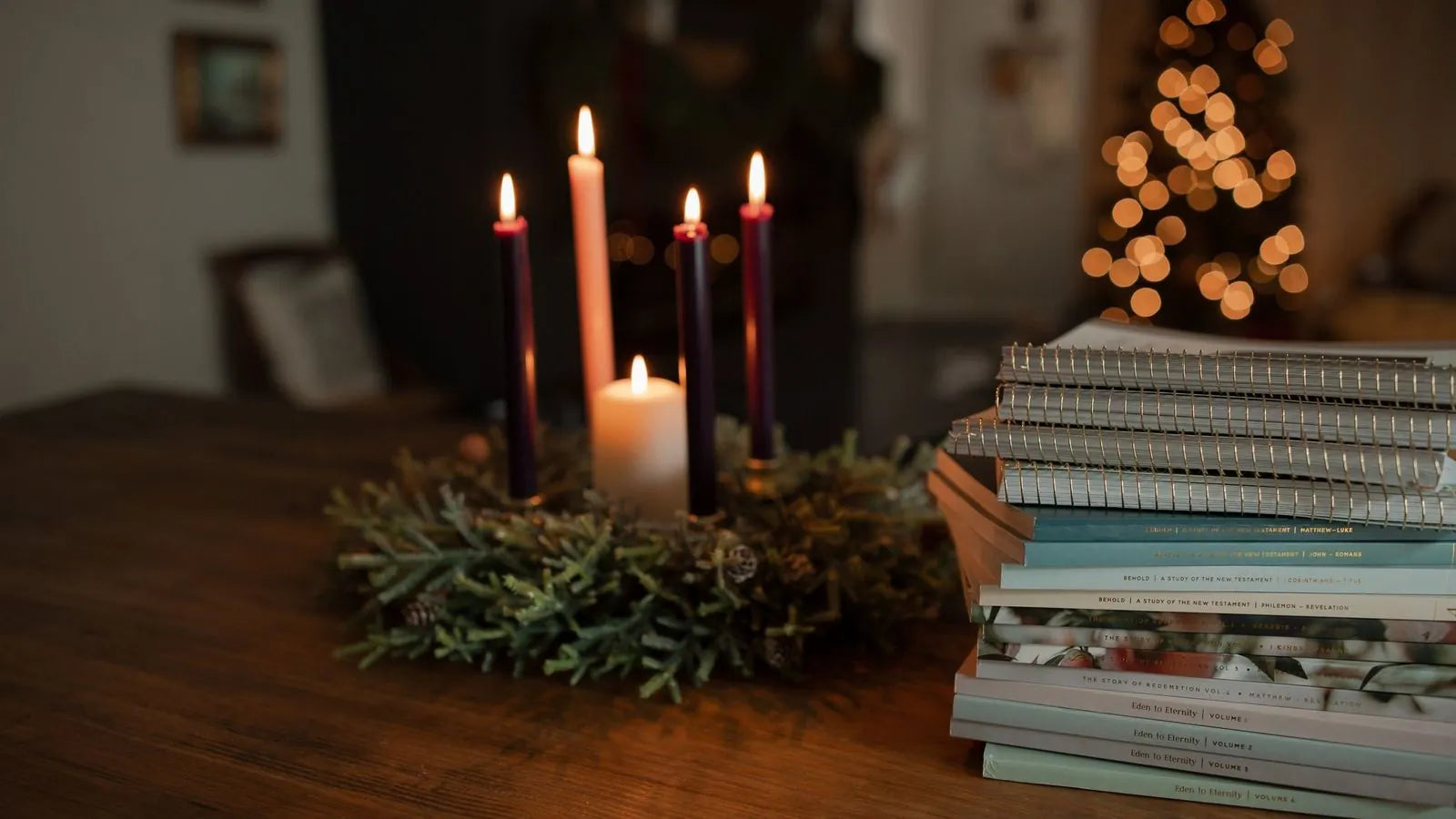 Candles lit next to a stack of daily grace studies