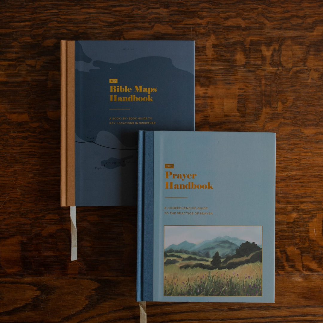 The Bible Maps Handbook and the Prayer Handbook next to each other on a wooden table