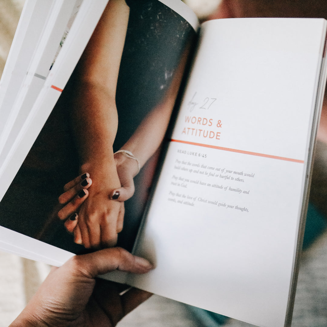 woman holding booklet open to pages with photo and text 