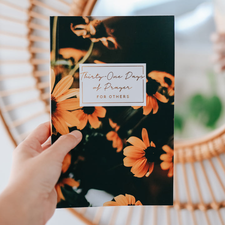 woman holding booklet to show cover