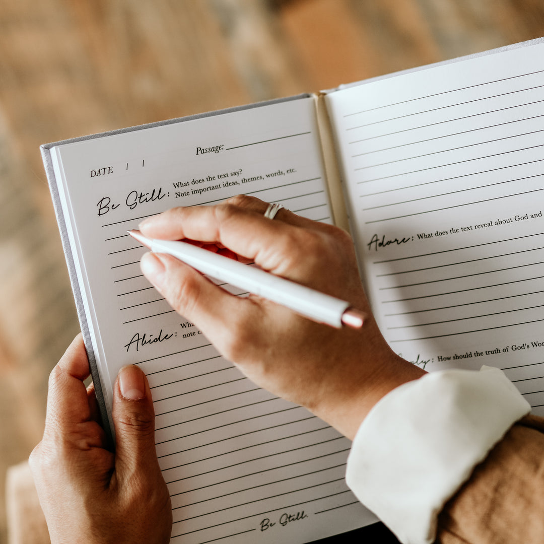 woman writing in bible study journal