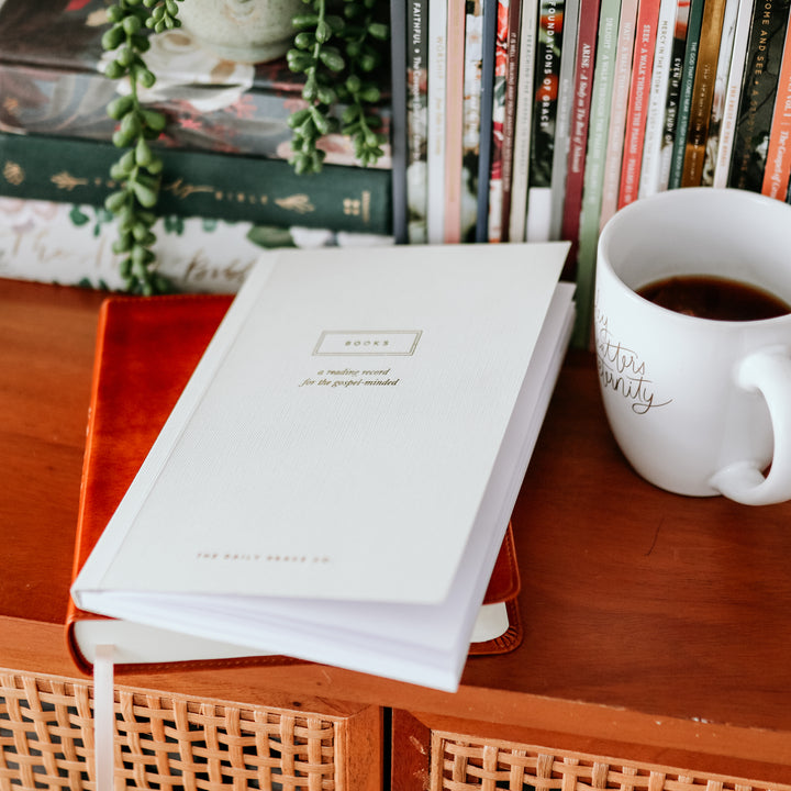 christian reading journal on shelf with bible and books