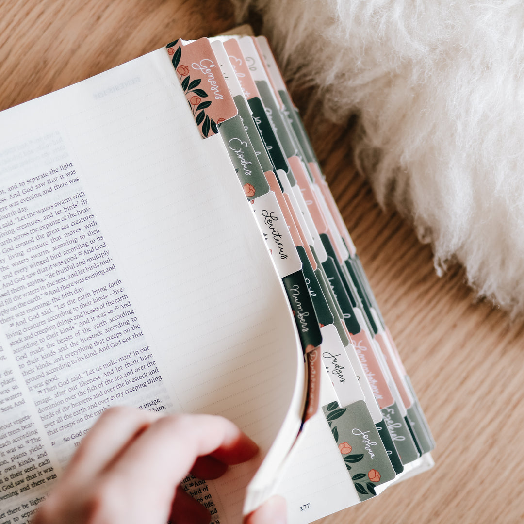 woman flipping through journaling bible with floral bible tabs