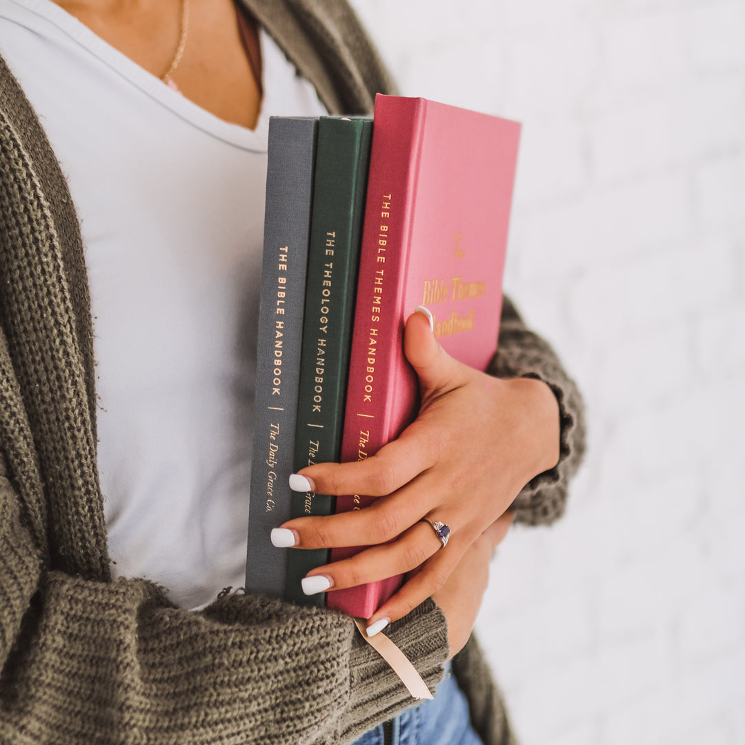 woman holding three handbooks