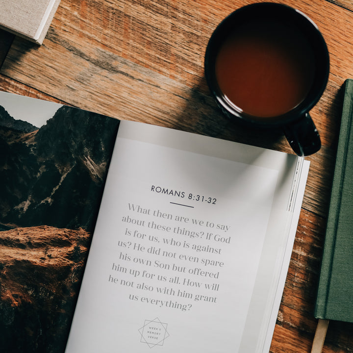 Romans 8:31–32 quote next to a coffee cup. 